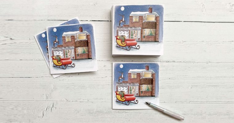 Three Christmas cards featuring a brick house with a sleigh outside the front and a reindeer on the roof, alongside a fountain pen