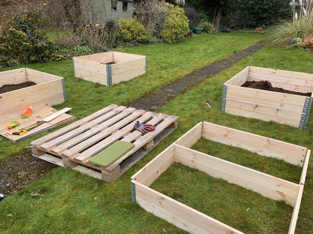 wooden raised beds being laid out, made from pallet collars