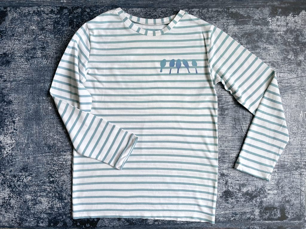 A stripy Childs top with long sleeves and blue-grey stripes, with a row of five bird silhouettes, also in blue, on the left side of the chest.
