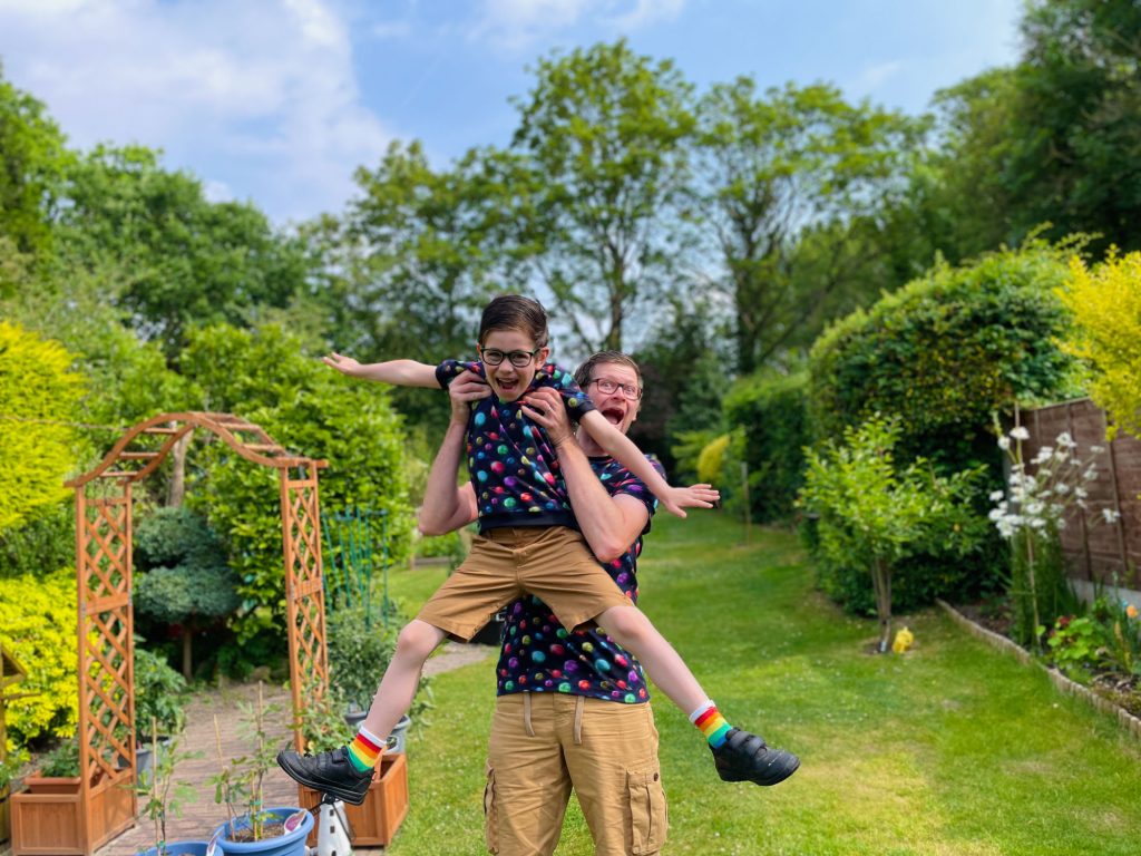 Father and son having fun in the garden whilst wearing matching t-shirts